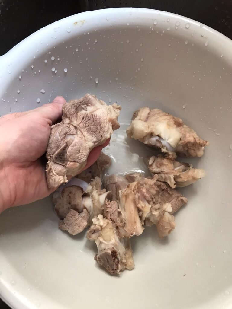 豬𦟌骨汆水後、洗淨中